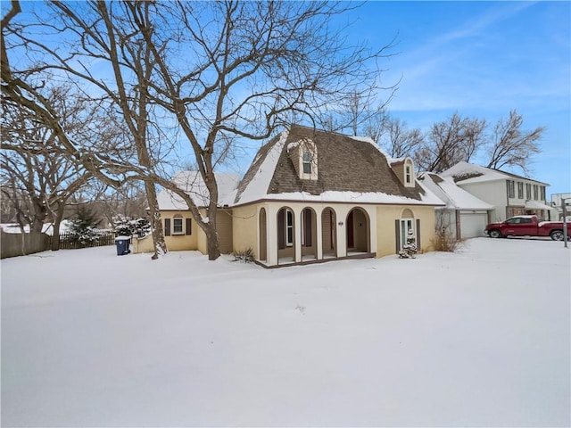 view of front of house with an attached garage, roof with shingles, and stucco siding