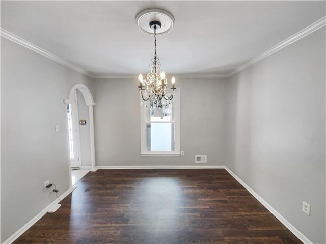 spare room featuring visible vents, wood finished floors, arched walkways, crown molding, and baseboards