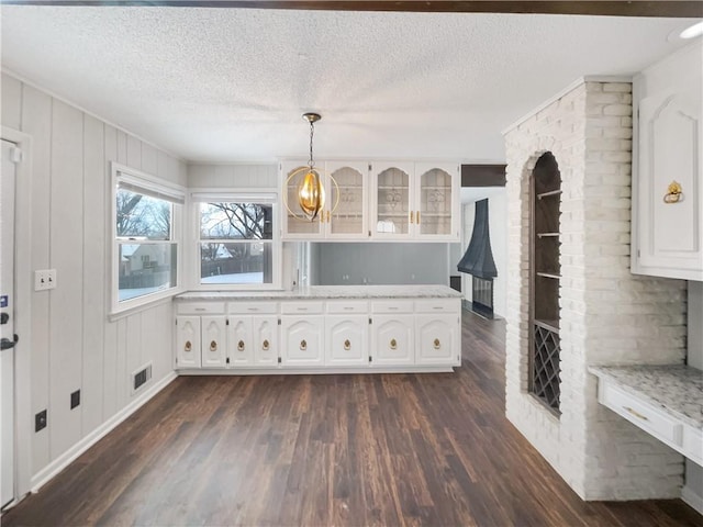 interior space with visible vents, a textured ceiling, and dark wood finished floors