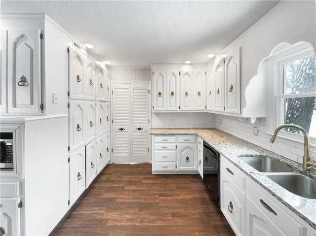 kitchen featuring a sink, tasteful backsplash, black dishwasher, dark wood finished floors, and white cabinetry