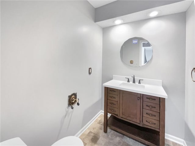 bathroom featuring vanity, toilet, recessed lighting, and baseboards