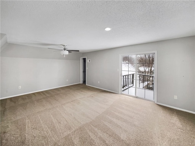 carpeted empty room with ceiling fan, baseboards, and a textured ceiling