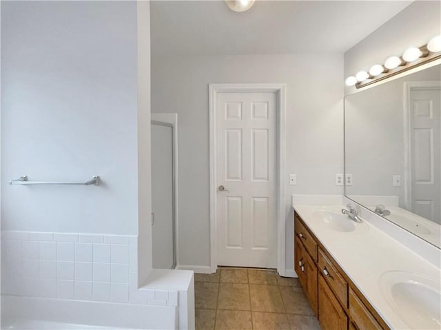 bathroom with double vanity, a bathtub, and a sink