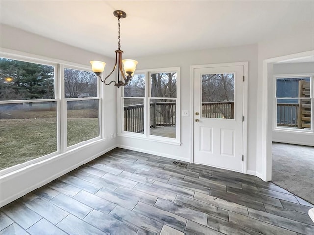 unfurnished sunroom featuring visible vents and a chandelier