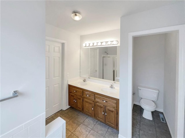 bathroom with a sink, visible vents, a stall shower, and double vanity