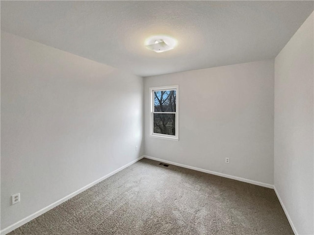 carpeted empty room featuring visible vents, baseboards, and a textured ceiling