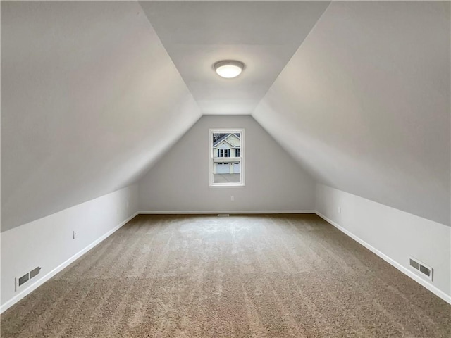 bonus room with lofted ceiling, baseboards, visible vents, and carpet floors