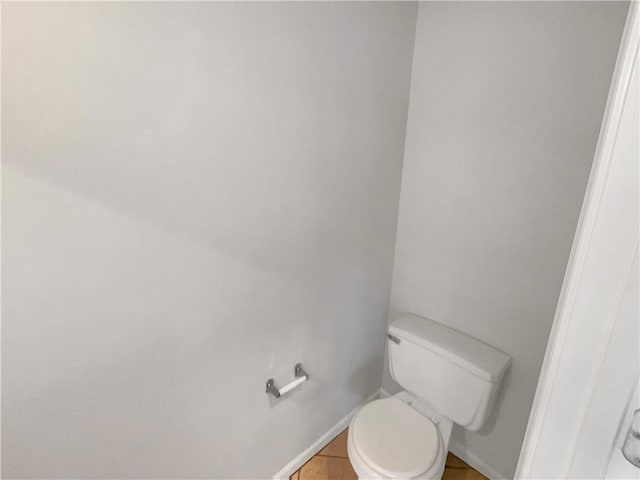 bathroom with toilet and baseboards