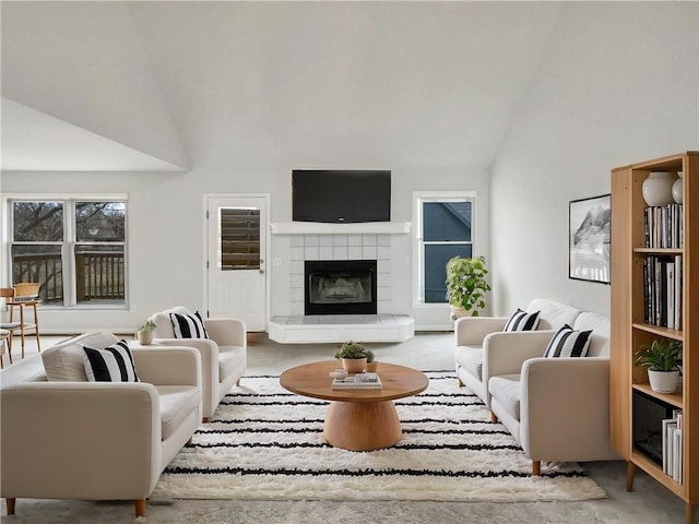 living room with carpet flooring, vaulted ceiling, and a tile fireplace