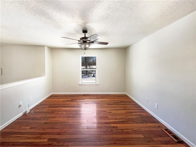 unfurnished room featuring visible vents, baseboards, ceiling fan, wood finished floors, and a textured ceiling