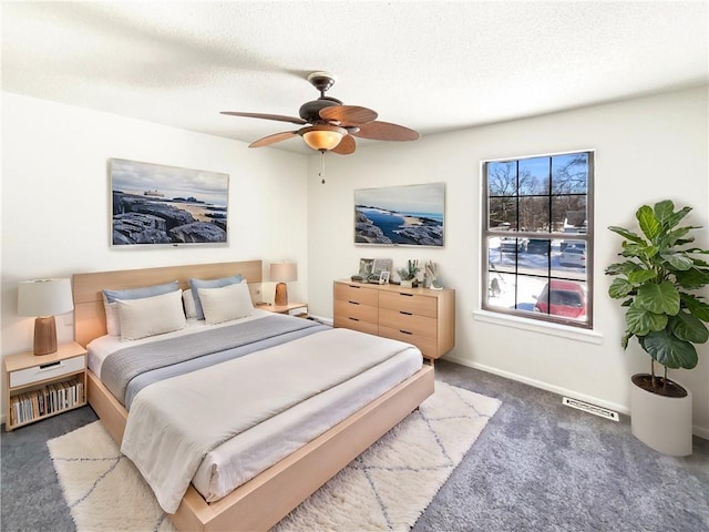 bedroom featuring a ceiling fan, baseboards, carpet, visible vents, and a textured ceiling