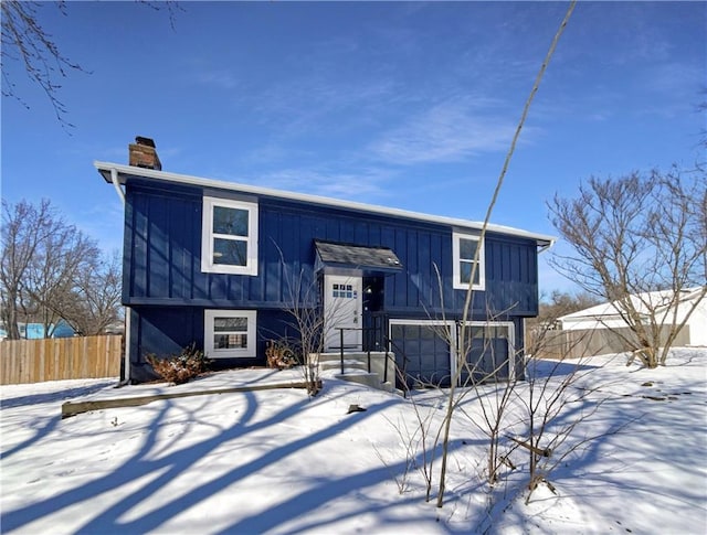 view of front of property with fence, board and batten siding, and a chimney