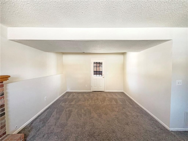 basement with baseboards, a textured ceiling, and carpet flooring