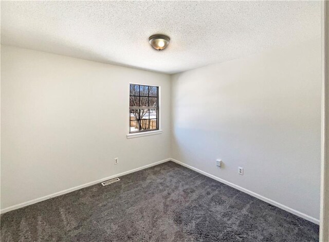 empty room with visible vents, baseboards, a textured ceiling, and dark carpet