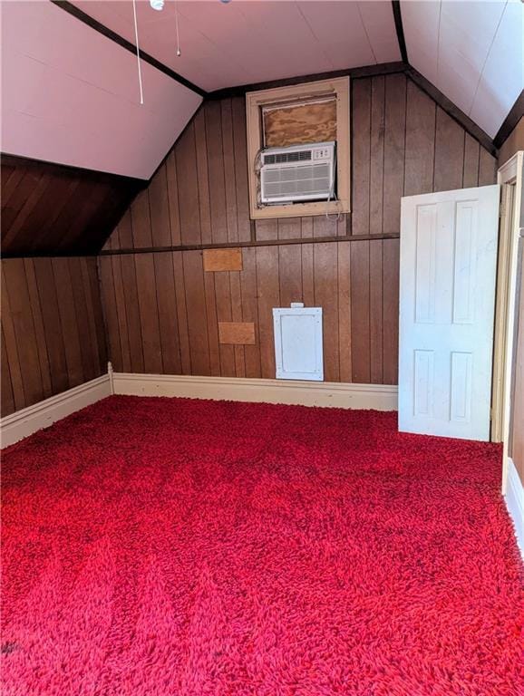 additional living space featuring lofted ceiling, carpet flooring, and a wall mounted AC