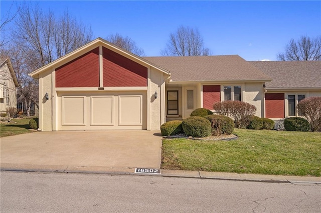 view of front facade with concrete driveway, a garage, a front yard, and stucco siding