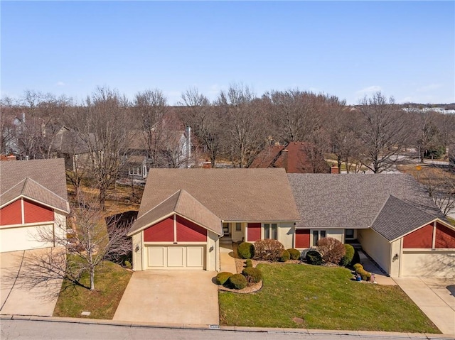 view of front of property featuring driveway, an attached garage, and a front lawn