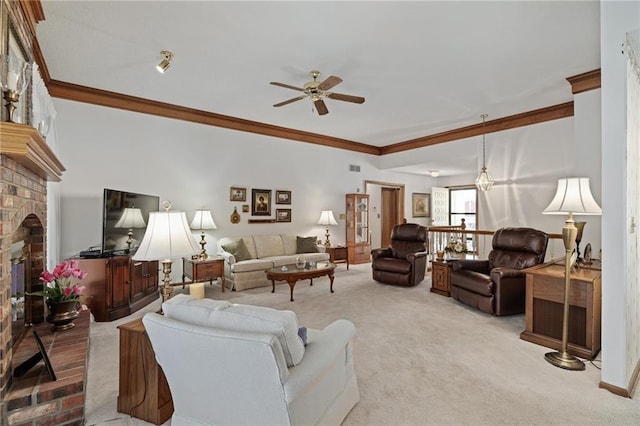 living area featuring light carpet, a brick fireplace, ceiling fan, and crown molding