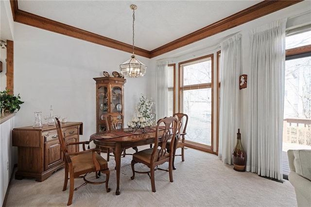 dining room with light carpet, an inviting chandelier, and ornamental molding