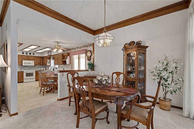 dining area with light carpet, crown molding, and baseboards