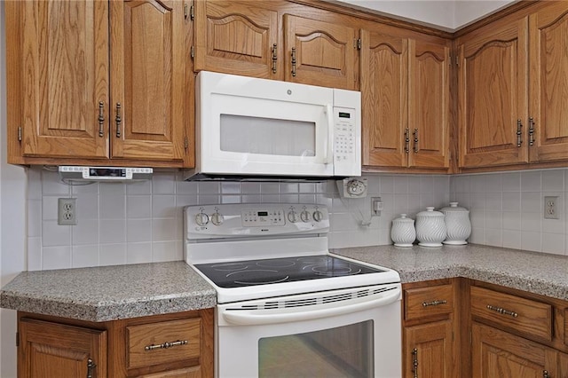 kitchen featuring white appliances, tasteful backsplash, brown cabinetry, and light countertops