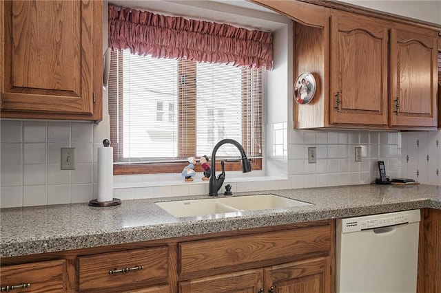 kitchen with a sink, brown cabinetry, white dishwasher, decorative backsplash, and light countertops