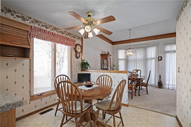 dining room featuring ceiling fan with notable chandelier, baseboards, visible vents, and a textured ceiling