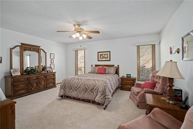 bedroom featuring carpet flooring, a ceiling fan, and a textured ceiling