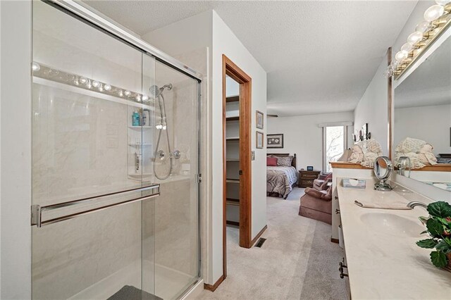 ensuite bathroom with vanity, ensuite bath, a stall shower, and a textured ceiling