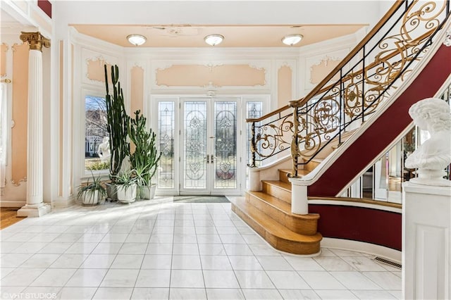 entrance foyer with tile patterned flooring, visible vents, stairway, french doors, and ornate columns