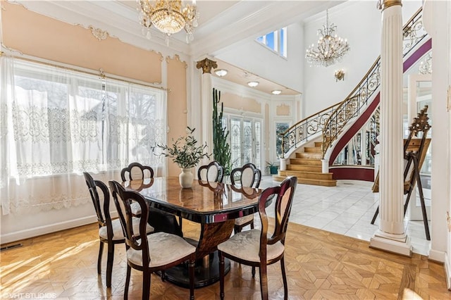 dining space with visible vents, crown molding, stairs, an inviting chandelier, and a towering ceiling