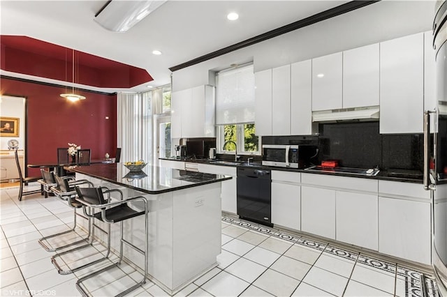 kitchen with black appliances, under cabinet range hood, a kitchen breakfast bar, dark countertops, and white cabinetry