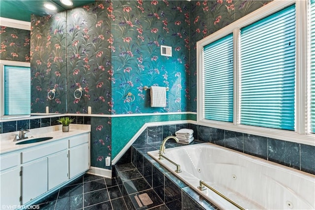 bathroom with vanity, a tub with jets, baseboards, wallpapered walls, and tile patterned floors