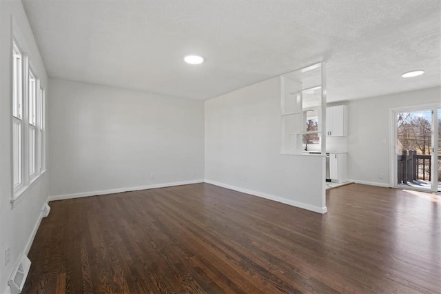 unfurnished living room with dark wood-style floors, visible vents, recessed lighting, and baseboards