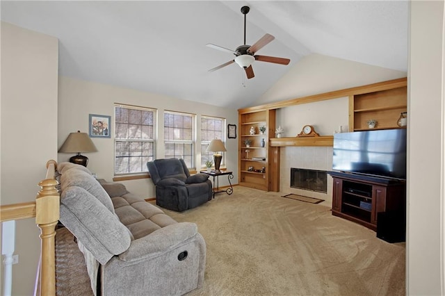 living area with built in shelves, a tiled fireplace, lofted ceiling, carpet flooring, and a ceiling fan