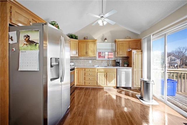 kitchen with backsplash, light brown cabinets, dark wood finished floors, light countertops, and stainless steel appliances