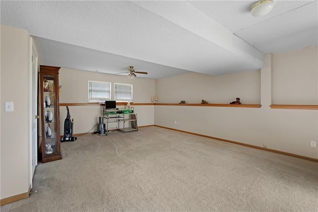 unfurnished office with baseboards, carpet, ceiling fan, and a textured ceiling