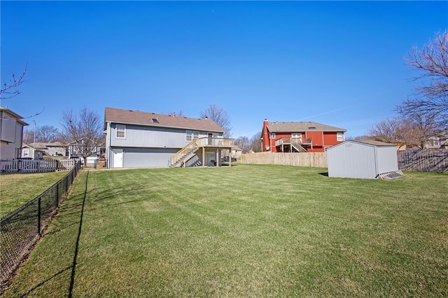 view of yard featuring a shed, stairs, an outdoor structure, a fenced backyard, and a deck