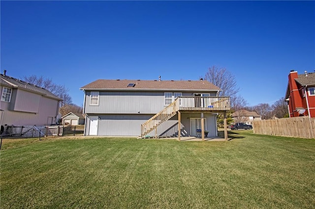 back of house featuring stairway, a lawn, a deck, and fence