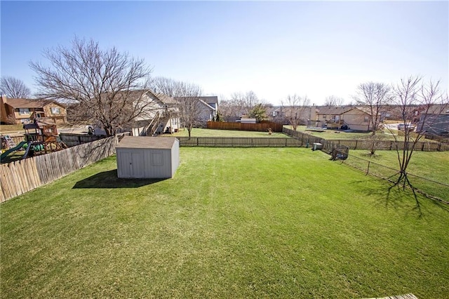 view of yard with a fenced backyard, a residential view, a storage shed, and an outdoor structure