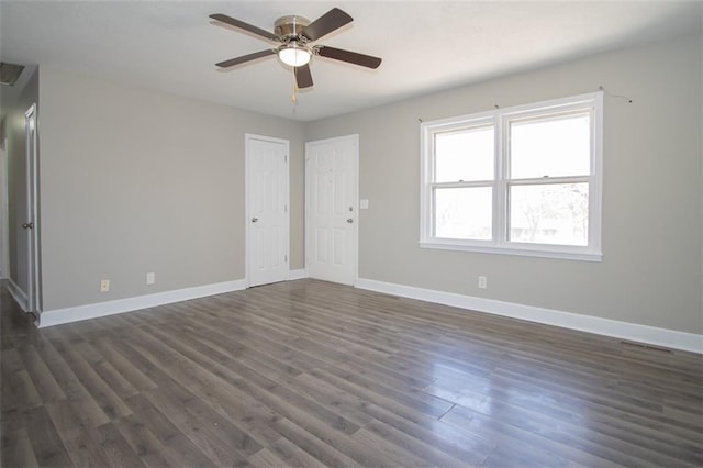 unfurnished room with ceiling fan, baseboards, and dark wood-style flooring