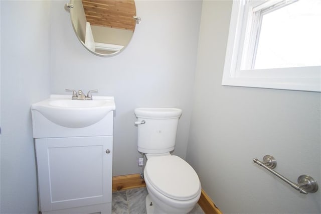 bathroom featuring vanity, toilet, and baseboards