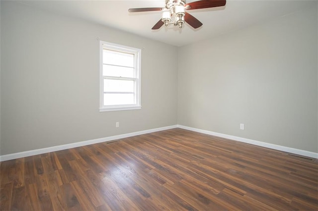 unfurnished room with baseboards, a ceiling fan, and dark wood-style flooring