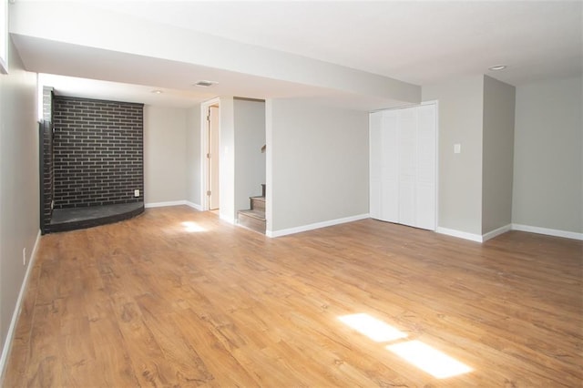 empty room featuring visible vents, baseboards, stairs, and light wood-style floors