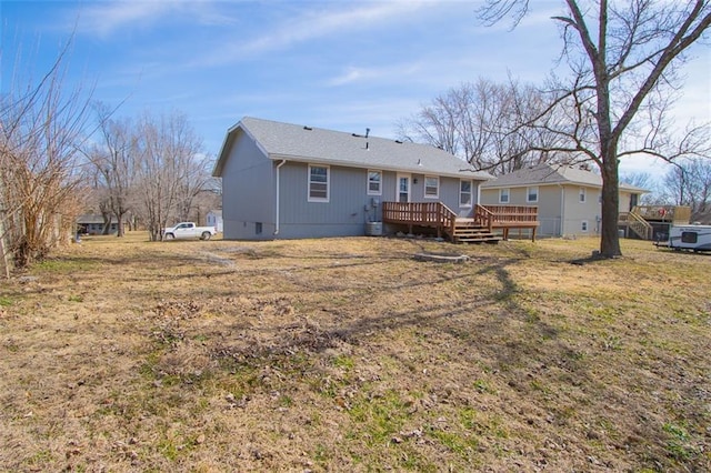 rear view of house featuring a yard and a deck