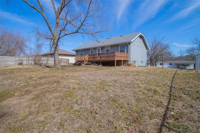 back of house featuring a lawn, a deck, and fence