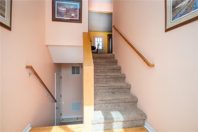 staircase with visible vents and baseboards