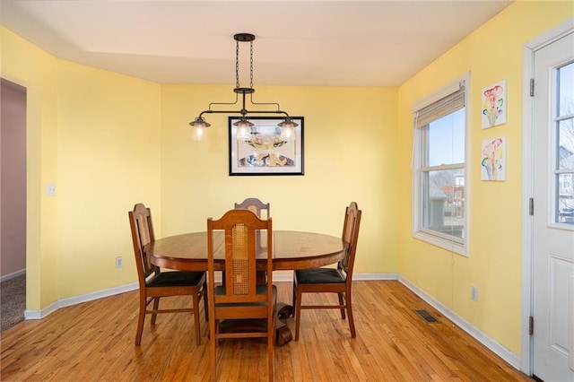 dining room with visible vents, light wood-style flooring, and baseboards