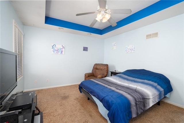 bedroom featuring a ceiling fan, baseboards, visible vents, a raised ceiling, and carpet flooring