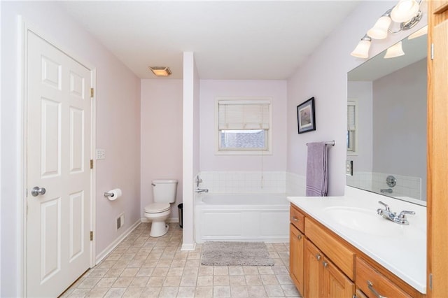 full bathroom featuring visible vents, baseboards, toilet, a garden tub, and vanity